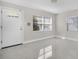 Inviting living room featuring a white front door, large windows with blinds, and marble-look tile flooring at 304 E Hanlon St, Tampa, FL 33604