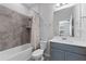 Well-lit bathroom featuring a shower-tub combination with tiled walls and sleek vanity with mirror at 34244 Radley Way, Wesley Chapel, FL 33545