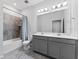 Bathroom featuring a double vanity, granite countertop, and shower with tub at 34244 Radley Way, Wesley Chapel, FL 33545