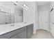 Bright bathroom with double vanity, granite countertop, and glass-enclosed shower at 34244 Radley Way, Wesley Chapel, FL 33545