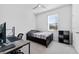 A minimalist bedroom setup with desk, chair, and twin bed by the window at 34244 Radley Way, Wesley Chapel, FL 33545