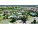 Aerial shot of the community pool, tennis courts, and surrounding houses with a pond nearby at 34244 Radley Way, Wesley Chapel, FL 33545