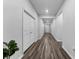 Long hallway with neutral walls and wood-look flooring, providing access to multiple rooms in the home at 34244 Radley Way, Wesley Chapel, FL 33545