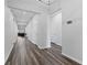 Hallway with hardwood floors connects the living spaces of this new home at 34244 Radley Way, Wesley Chapel, FL 33545