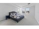 Relaxing main bedroom featuring tray ceiling, three large windows, and a decorative navy-blue bed frame at 34244 Radley Way, Wesley Chapel, FL 33545