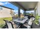 Covered patio with table, chairs, and outdoor decor in a well maintained backyard at 34244 Radley Way, Wesley Chapel, FL 33545
