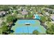 Aerial view of the community tennis courts with shade structure, and lush surrounding landscaping at 34244 Radley Way, Wesley Chapel, FL 33545