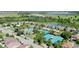 Aerial view of community with a pool and tennis courts, surrounded by well-maintained landscaping and ponds at 34311 Evergreen Hill Ct, Wesley Chapel, FL 33545
