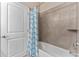 Bathroom features a tub with shower curtain and gray-tiled walls at 34311 Evergreen Hill Ct, Wesley Chapel, FL 33545