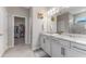 Modern bathroom featuring double sinks, granite countertops, and a walk-in closet at 34311 Evergreen Hill Ct, Wesley Chapel, FL 33545