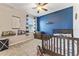 Stylish bedroom with ceiling fan, blue accent wall, window, carpet flooring, and decor at 34311 Evergreen Hill Ct, Wesley Chapel, FL 33545