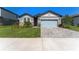 Single-story house with stone accents, light blue garage door, and a neatly landscaped front yard at 34311 Evergreen Hill Ct, Wesley Chapel, FL 33545