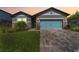 Attractive single-Gathering home showcasing a well-maintained lawn, stone detailing, and a blue garage door at 34311 Evergreen Hill Ct, Wesley Chapel, FL 33545