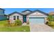 Charming single-story home featuring a well-manicured lawn, a blue door, and a two-car garage at 34311 Evergreen Hill Ct, Wesley Chapel, FL 33545