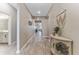 Long hallway features neutral walls, wood-look floors, and decorative console table with decor leading to other rooms at 34311 Evergreen Hill Ct, Wesley Chapel, FL 33545