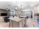 Bright open kitchen features large island with bar seating, granite countertops, stainless steel appliances, with a view to dining at 34311 Evergreen Hill Ct, Wesley Chapel, FL 33545