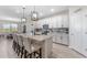 Modern kitchen featuring granite countertops, stainless steel appliances, and an expansive island with seating overlooking dining at 34311 Evergreen Hill Ct, Wesley Chapel, FL 33545