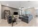 Open living room with plush seating, ceiling fan, and large windows bringing in natural light, on top of light wood floors at 34311 Evergreen Hill Ct, Wesley Chapel, FL 33545