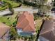 Aerial view of home showcasing a screened pool, terra cotta roof, and lush landscaping at 3635 80Th E Dr, Sarasota, FL 34243