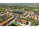 Aerial view of a residential community with houses, a pond, and green landscaping at 3635 80Th E Dr, Sarasota, FL 34243