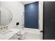 Modern bathroom featuring blue accent wall, round mirror, and stylish marble countertop at 3635 80Th E Dr, Sarasota, FL 34243