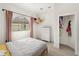 Bright bedroom with a large arched window, curtains, and view into a landscaped neighborhood at 3635 80Th E Dr, Sarasota, FL 34243