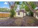 Backyard view with the exterior building surrounded by trees and a wooden fence at 3684 14Th Se Ave, Largo, FL 33771