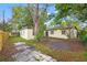 Backyard view with the exterior of the building surrounded by trees and a wooden fence at 3684 14Th Se Ave, Largo, FL 33771