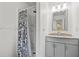 Updated bathroom features modern vanity with granite top, shower, and stylish curtain at 3684 14Th Se Ave, Largo, FL 33771