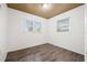 A bright bedroom with neutral wall paint, two windows, and laminate flooring at 3684 14Th Se Ave, Largo, FL 33771