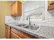 Kitchen sink with granite counters and modern faucet beneath a bright window at 3684 14Th Se Ave, Largo, FL 33771