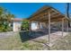 View of a carport with a metal roof next to a white house, surrounded by green plants at 3714 38Th N Ave, St Petersburg, FL 33713