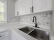 A close up of a stainless steel kitchen sink, modern faucet, quartz countertops, and mosaic backsplash at 3714 38Th N Ave, St Petersburg, FL 33713