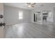 Bright, open-concept living room featuring gray wood floors, modern ceiling fan, and view of the kitchen at 3714 38Th N Ave, St Petersburg, FL 33713
