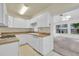 An open-concept kitchen flows into a sunroom with large windows, filling the space with natural light at 4227 Porpoise Se Dr, St Petersburg, FL 33705