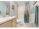 This bathroom has a shower and tub with a patterned shower curtain and light wood cabinets at 435 Kensington Lake Crk, Brandon, FL 33511