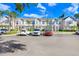 Townhouse complex with multiple parking spaces, set against a backdrop of blue skies and lush trees at 435 Kensington Lake Crk, Brandon, FL 33511