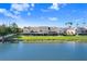 Exterior view of the condo buildings on a lake with well-manicured lawns and screened in lanais at 435 Kensington Lake Crk, Brandon, FL 33511