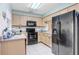 This kitchen features light wood cabinets, black appliances and granite countertops at 435 Kensington Lake Crk, Brandon, FL 33511