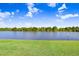 Beautiful lake view with green grass in the foreground and trees in the distance at 435 Kensington Lake Crk, Brandon, FL 33511