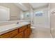 Bathroom features a vanity, mirror, toilet, and shower-tub combo at 5039 Gato Del Sol Cir, Wesley Chapel, FL 33544