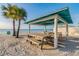 Gulf Harbors private beach with covered picnic tables under the bright sun at 5088 Royal Palms Way # 304, New Port Richey, FL 34652