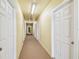 Neutral painted hallway with rows of identical doors and lights at 5088 Royal Palms Way # 304, New Port Richey, FL 34652