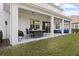 Back porch features outdoor dining and seating with a view of a large grassy yard at 5305 Sagecrest Dr, Lithia, FL 33547