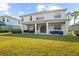 Backyard features a large grass lawn, a covered patio, and a white two-story home at 5305 Sagecrest Dr, Lithia, FL 33547