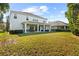 Backyard features a large grassy area, a covered patio, and a white two-story home at 5305 Sagecrest Dr, Lithia, FL 33547