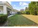 Backyard features a large grass lawn, a covered patio, and a well-manicured green hedge at 5305 Sagecrest Dr, Lithia, FL 33547