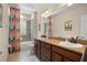 Bathroom with double sinks, modern fixtures, and colorful shower curtain next to the toilet and tub at 5305 Sagecrest Dr, Lithia, FL 33547