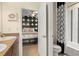 Bathroom with a glimpse into an adjacent bedroom; features a modern vanity and patterned shower curtain at 5305 Sagecrest Dr, Lithia, FL 33547