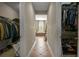 View through a long hallway showing tiled flooring, leading to closets and a window with natural light at 5305 Sagecrest Dr, Lithia, FL 33547